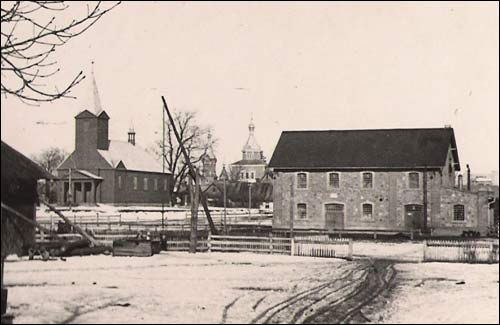  - Церковь Святой Троицы. Погляд на рынак у Вярховічах ад сядзібы Ротаў. Леваруч - касьцёл (цяпер - царква), праваруч - млын (не захаваўся), у цэнтры - царква XIX ст. (не захавалася). Здымак 1936 г. (з архіву Ротаў)